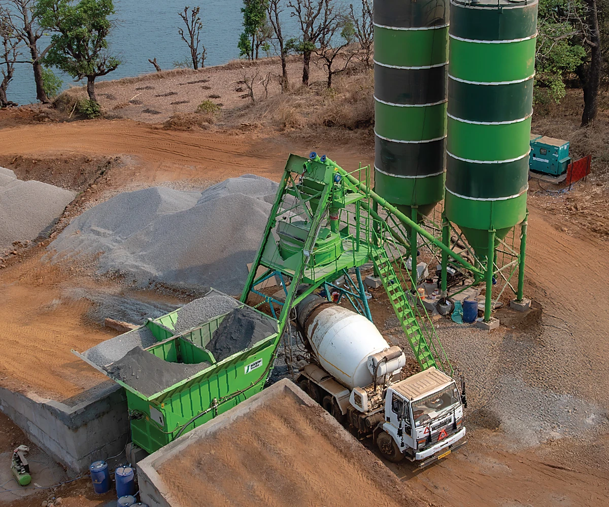 SCHWING mini batching plant producing concrete beside a lake project